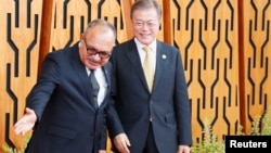 South Korea's President Moon Jae-in is shown the way by Papua New Guinea's Prime Minister Peter O'Neill as he arrives for the APEC Summit, Port Moresby, Papua New Guinea, Nov. 17, 2018. Moon is expected to discuss North Korea sanctions with Chinese President Xi Jinping.