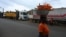 A woman selling carrots walks past trucks from Mali and Burkina Faso as they wait to load goods in the industrial area near Abidjan, Jan. 30, 2025, a day after Burkina Faso, Mali and Niger officially left the Economic Community of West African States, commonly known as ECOWAS.