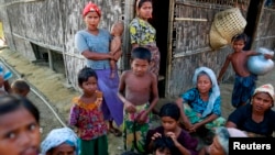 Rohingya Muslims pass time near their shelter at a refugee camp outside Sittwe, Myanmar, June 4, 2014.