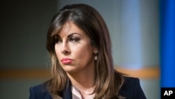 State Department spokeswoman Morgan Ortagus stands as Secretary of State Mike Pompeo speaks with reporters at the State Department, Nov. 26, 2019, in Washington.