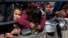 Niños palestinos esperan recibir comida cocinada en una cocina benéfica en medio de escasez de alimentos, mientras continúa el conflicto entre Israel y el grupo islamista palestino Hamás, en Rafah, en el sur de la Franja de Gaza, el 20 de febrero de 2024.