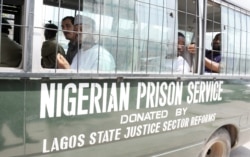Suspects sit on a bus taking them to prison after a hearing at the Federal High Court in Lagos, March 7, 2011. The prison service is now called the Nigerian Correctional Service.