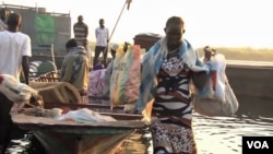 Refugees arrive by boat at the village of Mingkamen on the banks of the White Nile River