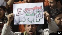 A Libyan protester holds up a sign against Libyan leader Moammar Gadhafi during a demonstration in Tobruk, Libya, February 23, 2011