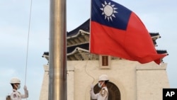 FILE - Two soldiers lower the national flag during the daily flag ceremony on Liberty Square of the Chiang Kai-shek Memorial Hall in Taipei, Taiwan, July 30, 2022. 