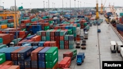 FILE - Workers are seen among the containers at Asia World port in Yangon, Myanmar, July 2, 2014. 