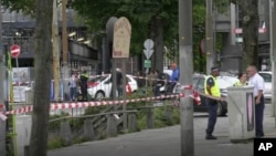 In this image made from video, Dutch police officers stand near the scene of a stabbing near the central daily station in Amsterdam, the Netherlands, Aug. 31, 2018.