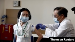 A medical worker receives a dose of the coronavirus disease (COVID-19) vaccine as the country launches its inoculation campaign, in Tokyo, Japan, Feb. 17, 2021.