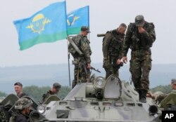 Confrontations continued Saturday between government troops and the Pro-Russian rebels. Ukrainian army paratroopers prepare to move to a position in Slovyansk, Ukraine, May 31, 2014.