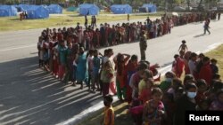 FILE - Women queue for food supplies at a camp for displaced earthquake victims in Kathmandu, Nepal, May 5, 2015. 