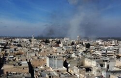 Smoke billows over the town of Saraqib in the eastern part of the Idlib province in northwestern Syria, following bombardment by Syrian government forces, Feb. 27, 2020.
