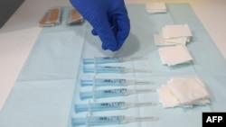 FILE - A nurse picks a syringe containing a dose of the AstraZeneca's COVID-19 vaccine at a vaccination center in Barcelona, Apr. 26, 2021. 