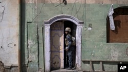 A federal policeman exits a house after searching it during fighting against Islamic State militants, on the western side of Mosul, Iraq, March 29, 2017. 