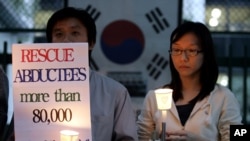 FILE - Members of the Korean Abductees to North Korea, the supporting group for those abducted by North Korea at the 1950-53 Korean War, participate at an anti-Koreas Summit candle rally in front of the government house in Seoul, South Korea, Oct. 2, 2007