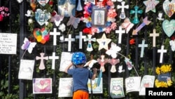 FILE - A child looks at the "Naming the Lost Memorials," at The Green-Wood Cemetery in Brooklyn, New York, June 10, 2021. 