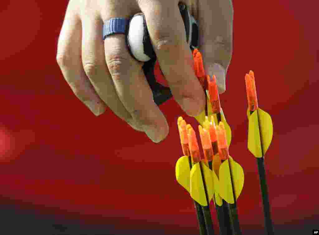 Atlet Kim Woo-jin mengambil panah dalam putaran peringkat individual pertandingan panahan sebelum pembukaan Olimpiade Musim Panas 2016 di Rio de Janeiro, Brazil (5/8). (AP/Alessandra Tarantino)