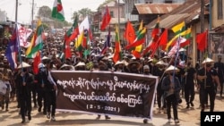 Protesters holding a banner and flags take part in a demonstration against the military coup on "Global Myanmar Spring Revolution Day" in Kyaukme in Myanmar's Shan State, May 2, 2021. (Credit: Shwe Phee Myay News Agency)
