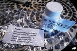 Lung cancer patient and advocate Jill Feldman takes pills at home that shrink tumors by blocking a signal that tells cancer cells to grow. (AP Photo/Nam Y. Huh)