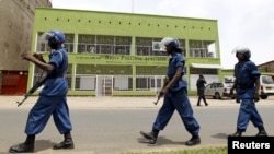 FILE - Riot police walk outside the Radio Publique Africaine broadcasting studio in Burundi's capital, Bujumbura, Apr. 26, 2015. 