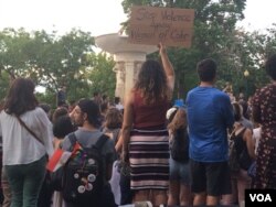 Attendees of a vigil honoring Nabra Hassanen carry signs calling for protection of women of color (E. Sarai/VOA)