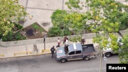 La periodista venezolana Carmela Longo camina hacia un vehículo policial mientras es detenida por la policía que allanó su casa, según un sindicato de periodistas y una organización de derechos locales, en Caracas, Venezuela, el 25 de agosto de 2024 en esta captura de pantalla.