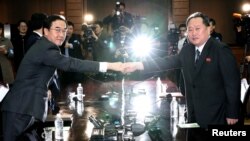 Menteri Unifikasi Korea Selatan Cho Myoung-gyon dan rekan Korea Utara Ri Son Gwon berpose untuk foto sebelum pertemuan mereka di desa gencatan senjata Panmunjom, Korea Utara, 29 Maret 2018.
