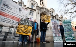 Pro and anti-Brexit protesters stand outside the Supreme Court on the third day of the challenge against a court ruling that Theresa May's government requires parliamentary approval to start the process of leaving the European Union, in Parliament Square.