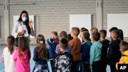 Arhiva - Učiteljica i đaci u jednoj osnovnoj školi u okolini Beograda, prvog dana školske godine tokom pandemije Kovida 19, u Srbiji, 1. septembra 2021.