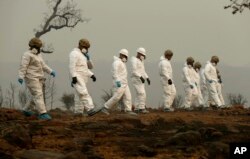 Members of the California Army National Guard search a property for human remains at the Camp fire, Nov. 14, 2018, in Paradise, Calif.