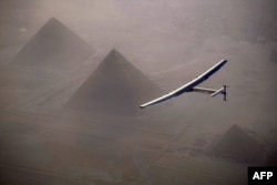 This handout photo released by Solar Impulse 2 shows the solar powered plane, piloted by Swiss pioneer André Borschberg, during the flyover of the pyramids of Giza on July 13, 2016 prior to landing in Cairo, Egypt.