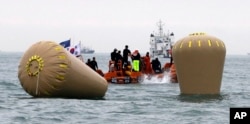 A rescue diver jumps in near the buoys installed to mark the sunken 6,852-ton ferry Sewol in the water off the southern coast near Jindo, south of Seoul, South Korea, April 18, 2014.