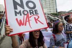 FILE - Ethnic Chin people hold placards during a protest asking for an end to conflict between the Myanmar military and the Arakan Army in Chin state and Rakhine state in Yangon, Myanmar, July 13, 2019.