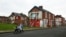 FILE - A woman pushes a stroller along a semi-derelict street in the Gresham area of Middlesbrough, northern Britain, Jan. 20, 2016. Asylum seekers in the northern English town of Middlesbrough are often suffering abuse.