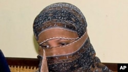Pakistani Christian woman Asia Bibi, listens to Governor of Pakistani Punjab Province Salman Taseer, unseen, at a prison in Sheikhupura near Lahore, Nov. 20, 2010. 