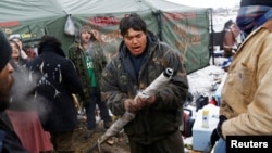 Oscar High Elk, 26, of the Cheyenne River Sioux Tribe, prays as he and other members of the tribe prepare to evacuate from the main opposition camp against the Dakota Access oil pipeline near Cannon Ball, N.D., Feb. 22, 2017. 