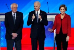 Democratic presidential candidates from left, Sen. Bernie Sanders, I-Vt., former Vice President Joe Biden and Sen. Elizabeth Warren, D-Mass., stand on stage, Feb. 7, 2020, before the start of a Democratic presidential primary debate.