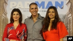 FILE - Bollywood actor Akshay Kumar, center, with his wife Twinkle Khanna, left, and actress Radhika Apte pose for the media during the song launch of their film "Padman" in Mumbai, India, Dec. 20, 2017.