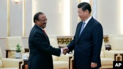 Chinese President Xi Jinping, right, shakes hands with Indian National Security Adviser Shivshankar Menon prior to a meeting at the Great Hall of the People in Beijing, Sept. 9, 2014.