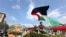 FILE - A demonstrator waves a flag on the Columbia University campus at a pro-Palestinian protest encampment, in New York, April 29, 2024.