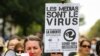 A woman wearing a yellow vest and speaking in a loud hailer, holds a placard reading "Media are the virus ..." during a demonstration against the mandatory COVID-19 health pass in Paris on Sept. 4, 2021