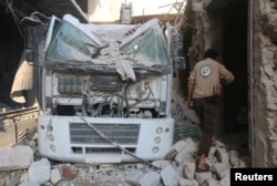 A civil defense member inspects the damage after their center was hit by an airstrike in a rebel-held area of Aleppo, Syria, Aug. 12, 2016.