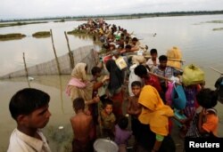 Rohingya refugees wait for boat to cross a canal after crossing the border through the Naf river in Teknaf, Bangladesh, Sept. 7, 2017.