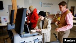 An election official helps a voter to cast her ballot at a polling station in Ridgeland, Mississippi, U.S., Nov. 27, 2018. 