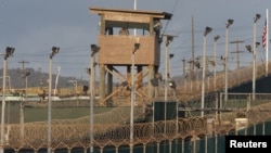 FILE - A US military member mans one of the watch towers at Camp Delta at the US Detention Center in Guantanamo Bay, Cuba. Another prisoner has been released from the detention center.