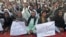 People hold signs as they chant slogans during a protest against satirical French weekly newspaper Charlie Hebdo, in Quetta, Pakistan, Jan. 15, 2015.