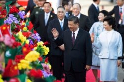 Chinese President Xi Jinping, front left, and his wife Peng Liyuan, front right, wave after arriving at Macao Airport, Dec. 18, 2019.