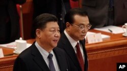 FILE - Chinese President Xi Jinping, left, and Chinese Premier Li Keqiang arrive at the opening session of China's National People's Congress at the Great Hall of the People in Beijing, March 5, 2019. 