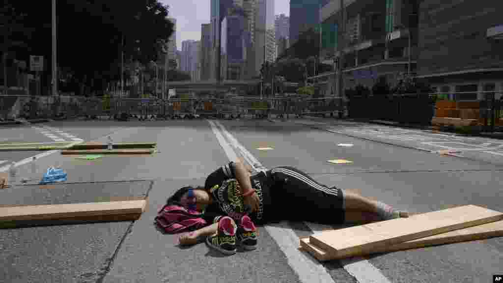 Seorang pelajar yang ikut berdemonstrasi tidur di tengah jalan di Hong Kong (5/10).&nbsp;(AP/Wally Santana) 