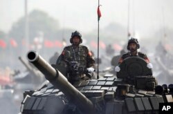 FILE - Myanmar military tanks are driven during a parade to commemorate the nation's 72nd Armed Forces Day in Naypyitaw, March 27, 2017.