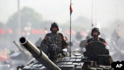 FILE - Myanmar military tanks are driven during a parade to commemorate the nation's 72nd Armed Forces Day in Naypyitaw, March 27, 2017.